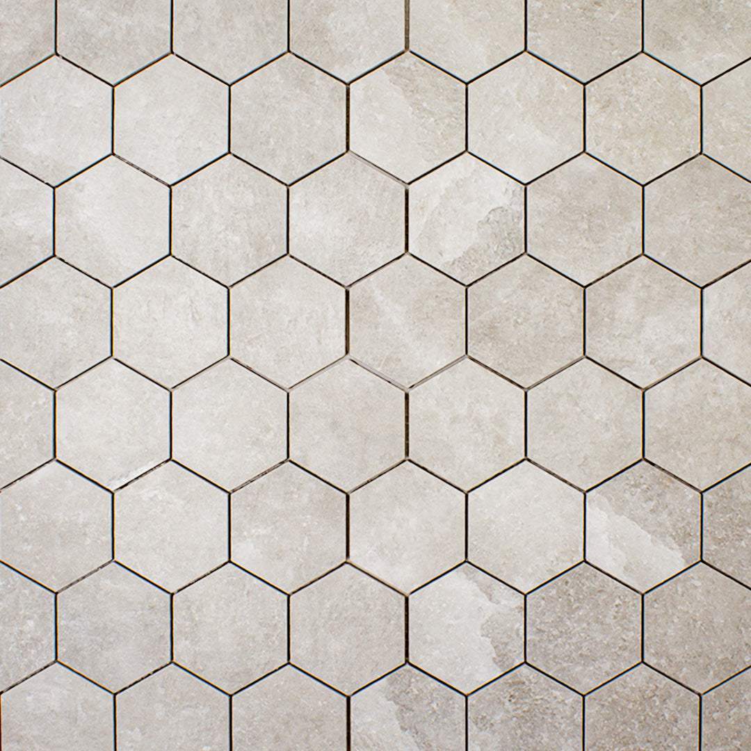 ariel view of A 3" hexagon mosaic tile in a beige taupe stone look showing the colour variation and texture. 