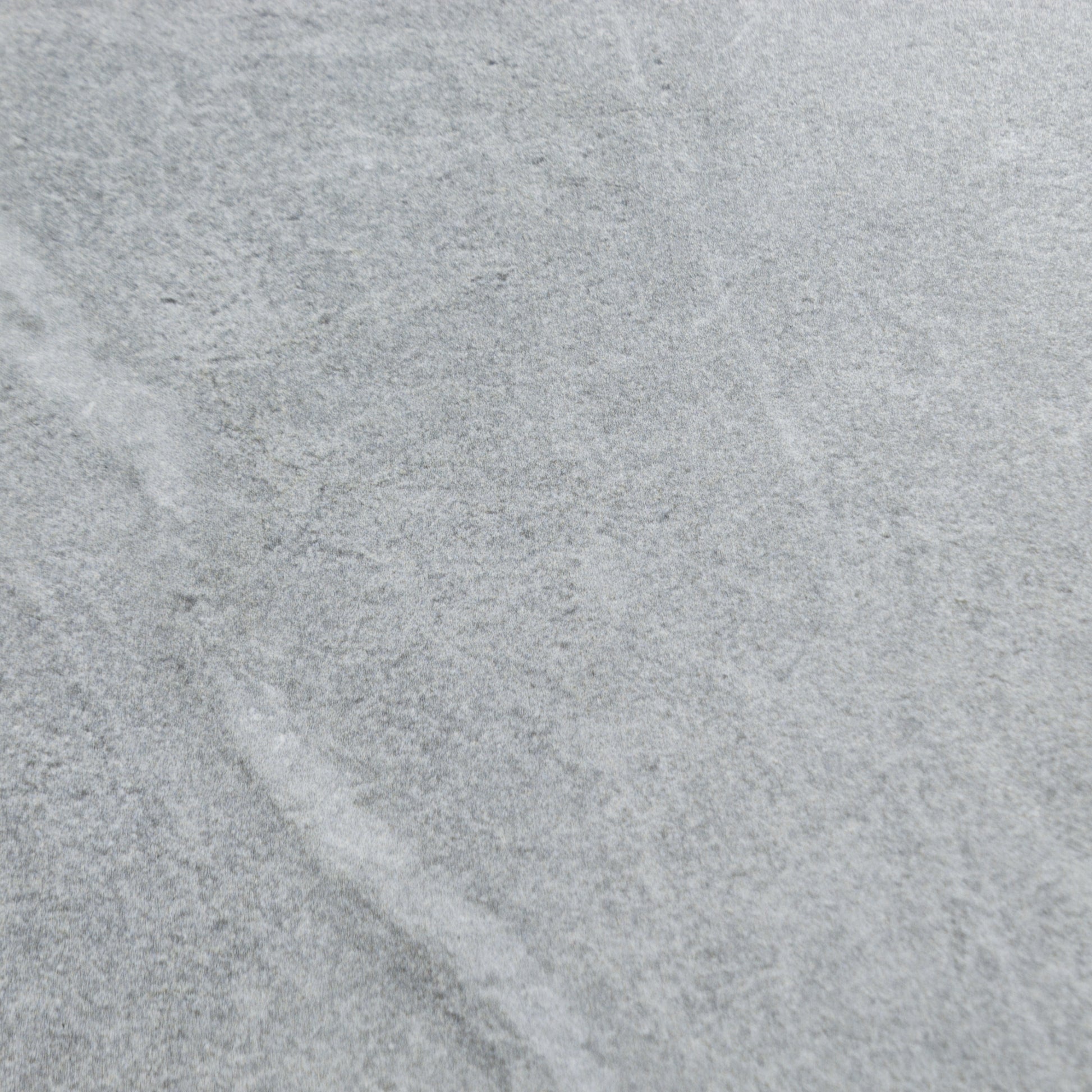 Close up of a large blue grey stone look tile with grey and white veining patterns. 