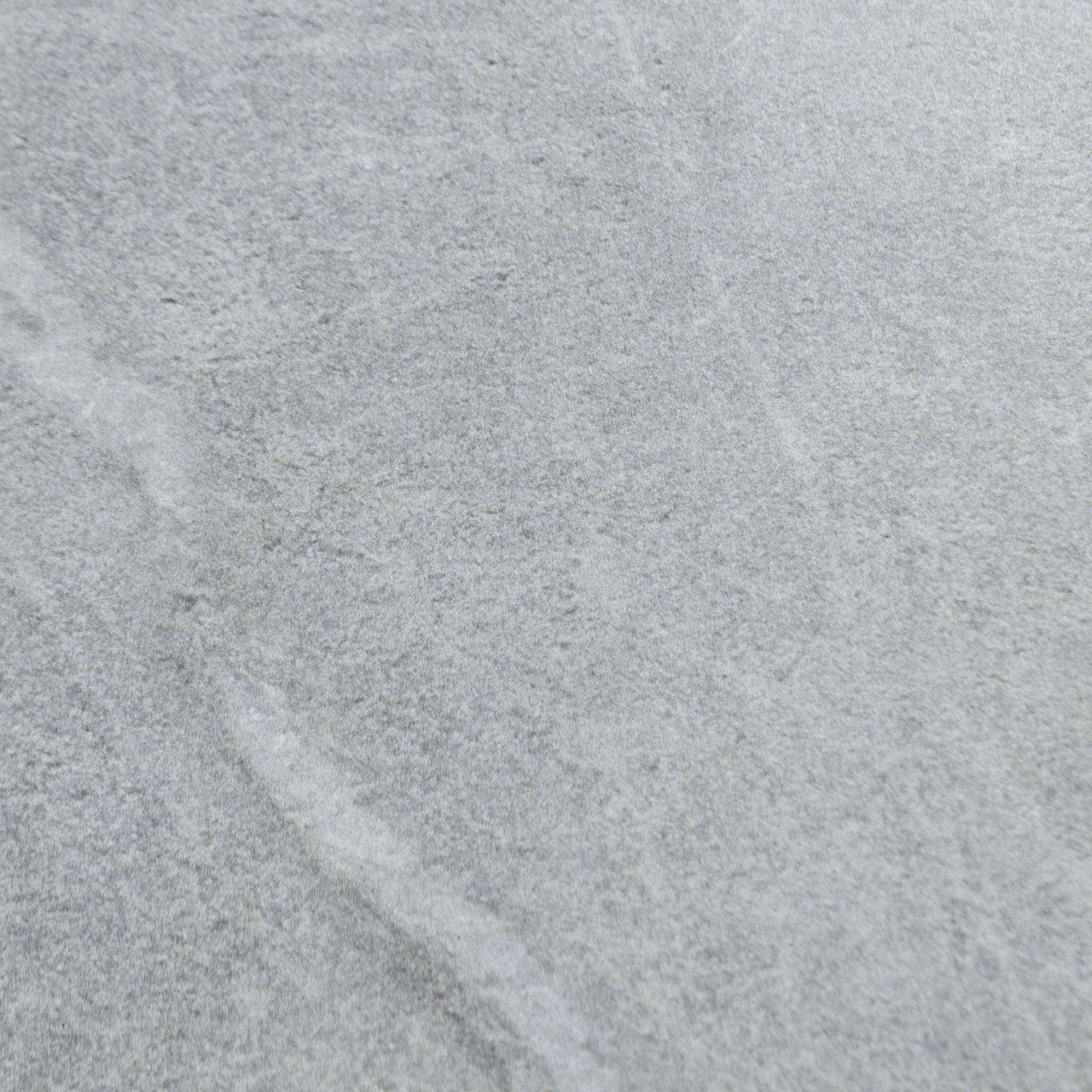 Close up of a large blue grey stone look tile with grey and white veining patterns. 