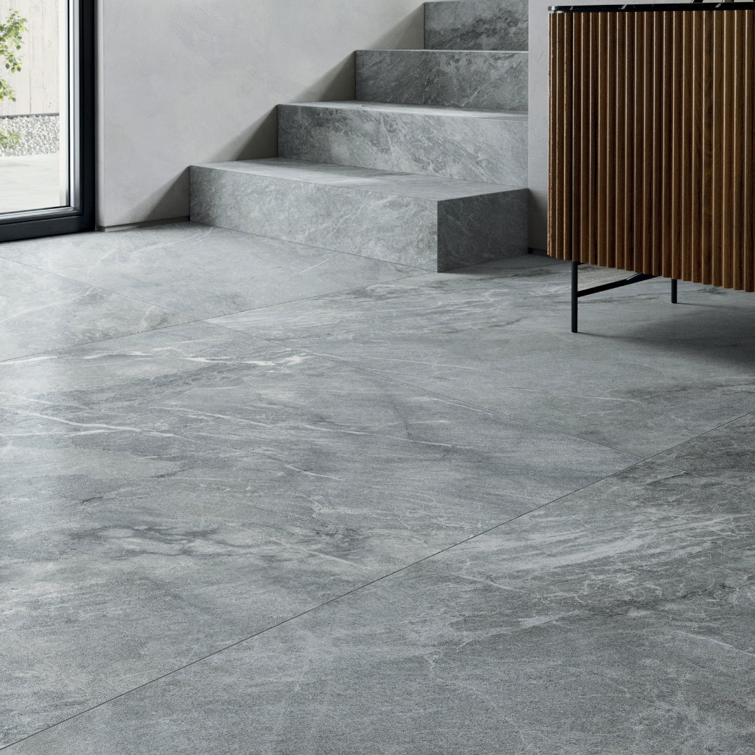 Interior flooring and stair installation of  a large blue grey stone look tile with grey and white veining patterns. 