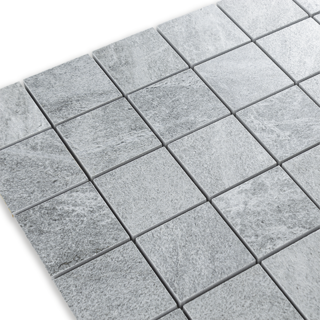 Angled close up of a light cement grey 2x2 stone look mosaic tile sheet