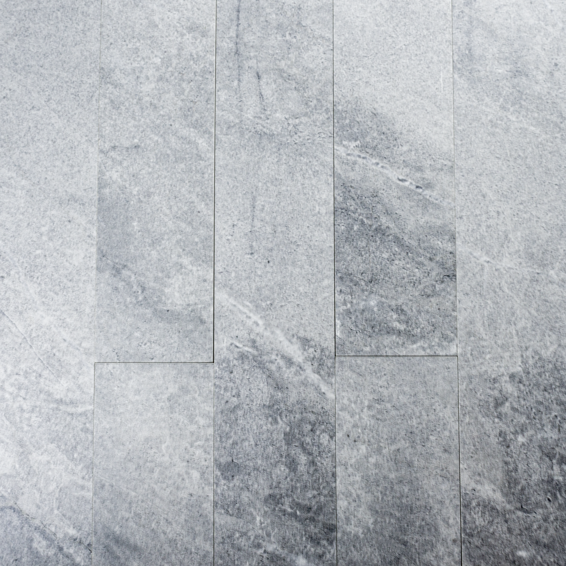 Ariel view of a group of 4x24 light grey stone look tiles in a brick layout. 