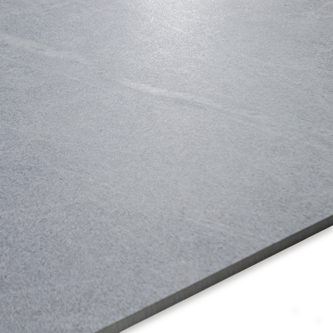 Angled close up of a ight grey large tile showing the veining and pattern. 
