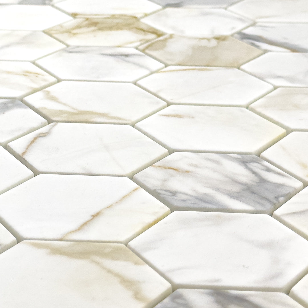 Close up angled view of white and grey and golden veining marble look porcelain 3 inch hexagon mosaic tiles.