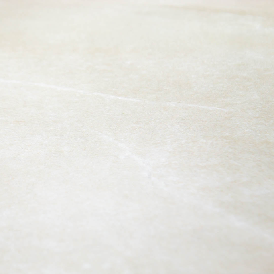 Close up of a warm and light stone look tile with fine details and pattern in 24x48