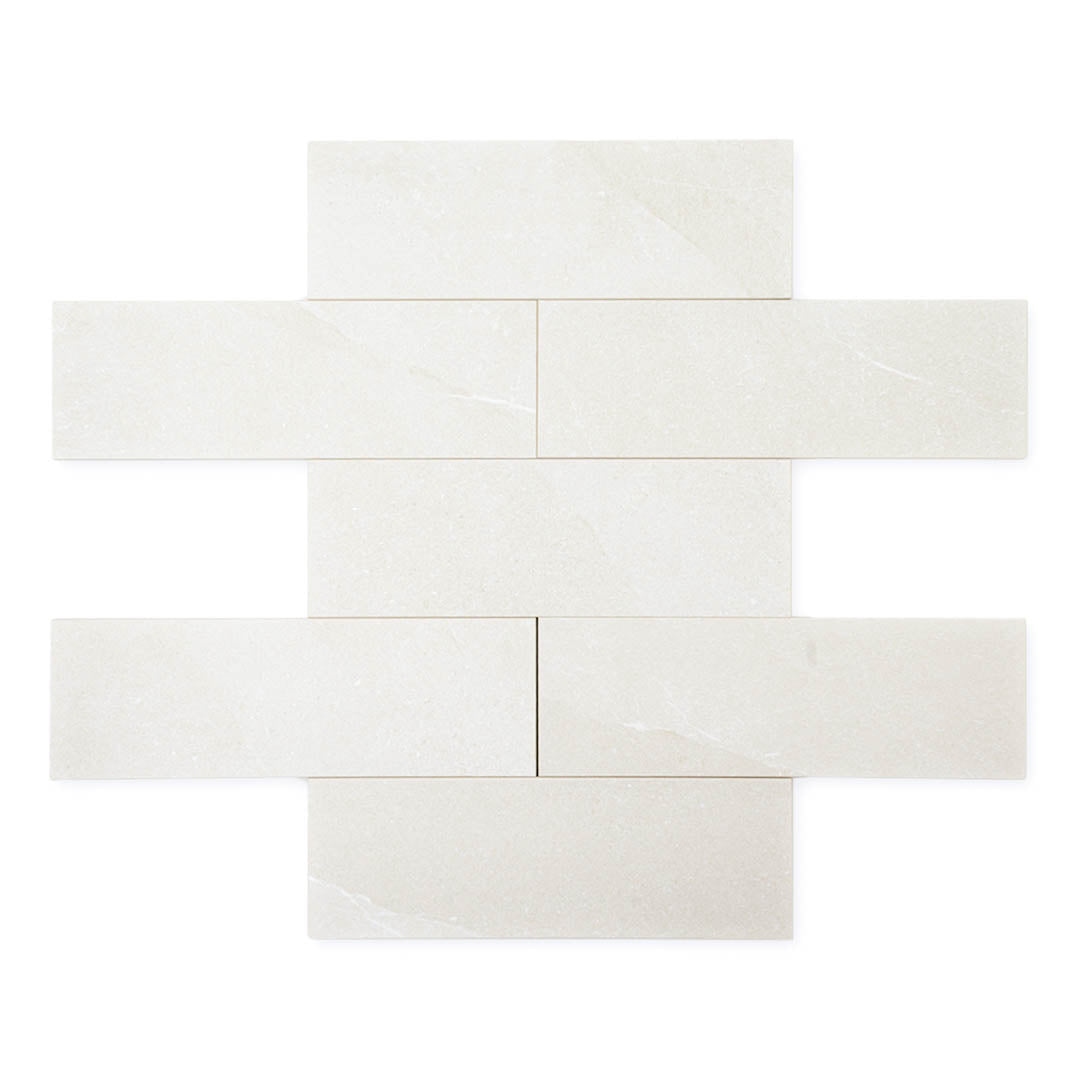 limestone look 4x12 matte tile in a light grey laid out in a brick pattern to show the pattern and variance.