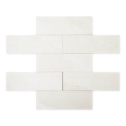 limestone look 4x12 matte tile in a light grey laid out in a brick pattern to show the pattern and variance.