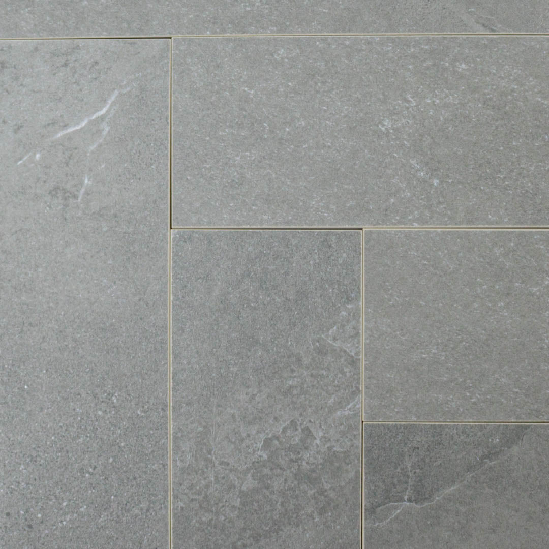 limestone look 4x12 matte tile in a dark grey laid out in a brick pattern to show the pattern and variance.