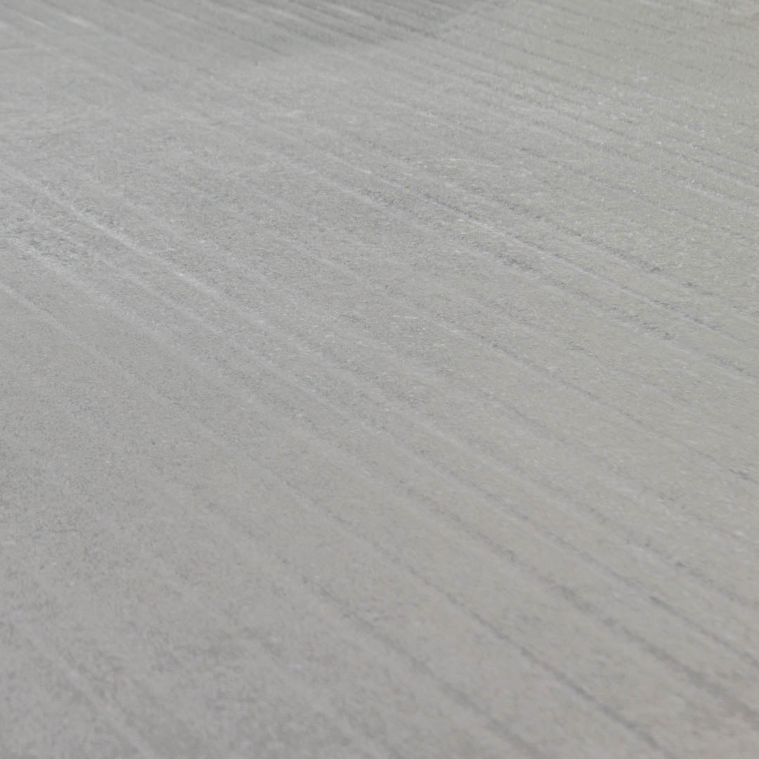 Angled close up of the dark gray limestone textured tiles that have the grain like stripes across the width of the 24x48 tile. 