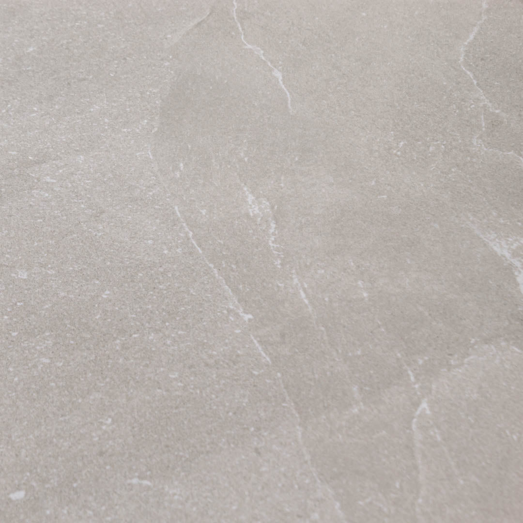 Close up to highlight the colour and veining of the 24x24 square limestone look warm greige stone taupe tile stonehaven