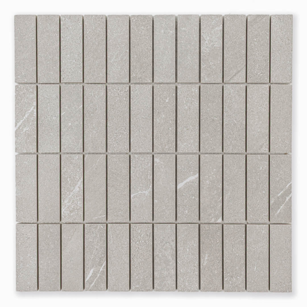 Stacked 1x3 chip mosaic sheet of tile that looks like limestone in a taupe shade with light veining pattern