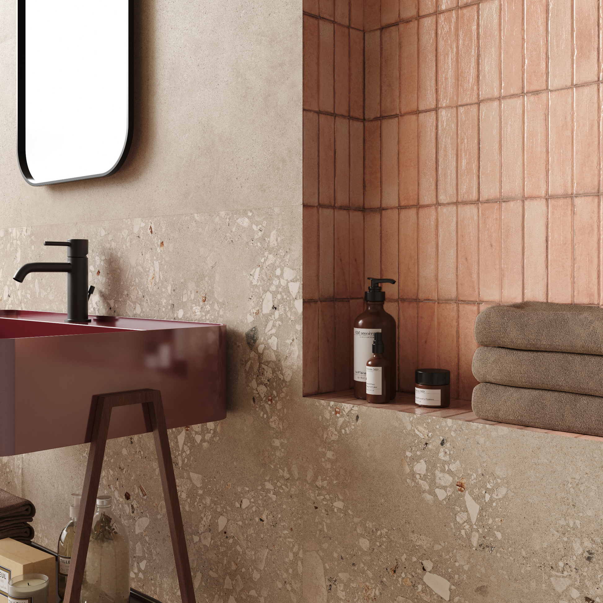 a close up of a bathroom vanity backsplash with a red sink and dark beige cement terrazzo look tiles on the wall. there is an alcove next to the sink for storage and it is lined with salmon pink tiles. 
