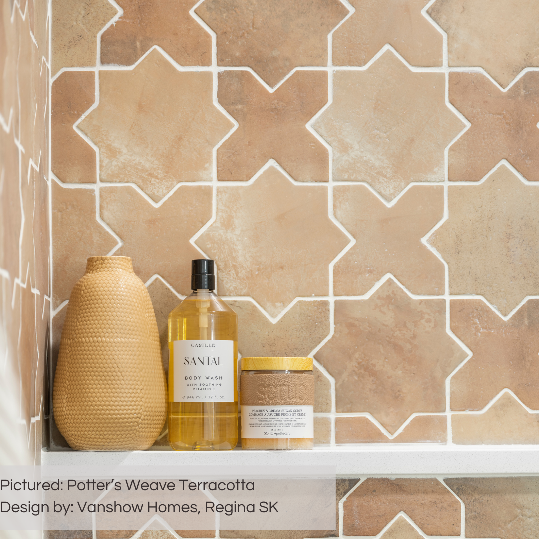 A close up photo of a shelf in a shower the tiles are a variated terracotta star and cross with texture and light grout. 