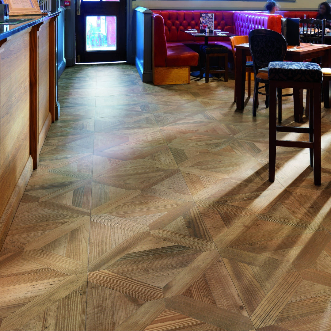 A commercial restaurant setting with 19x19 parquet wood look porcelain tile in a oak blonde light brown colour on the floors.  