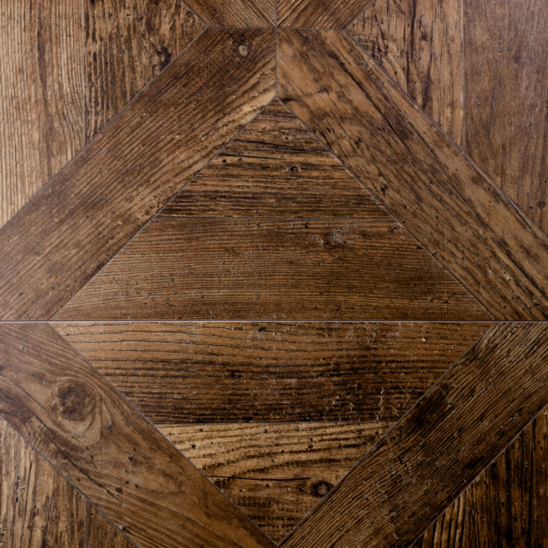 A close up of two 19x19 parquet wood look porcelain tiles in a medium walnut caramel brown.  