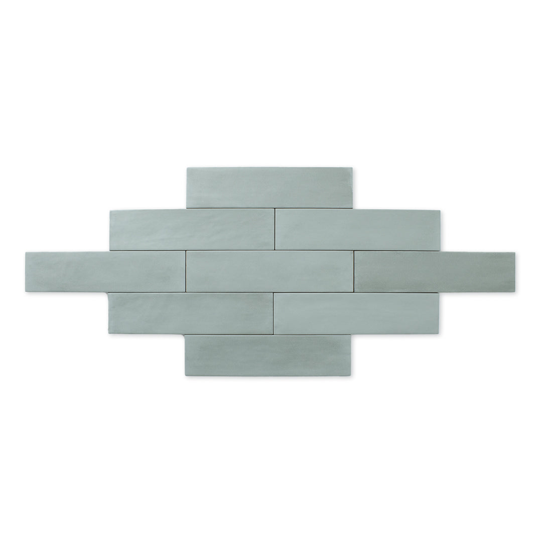 Product photo of multiple tiles laid out in a brick formation of the 2x9 matte subway tile in a soft green shade with subtle texture.