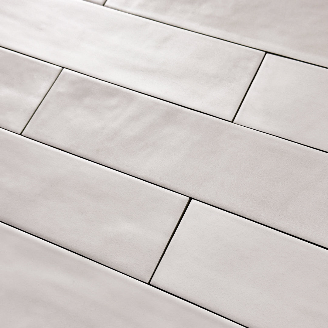 Close up detailed view of a 2x9 matte subway tile in a light grey shade with subtle texture.