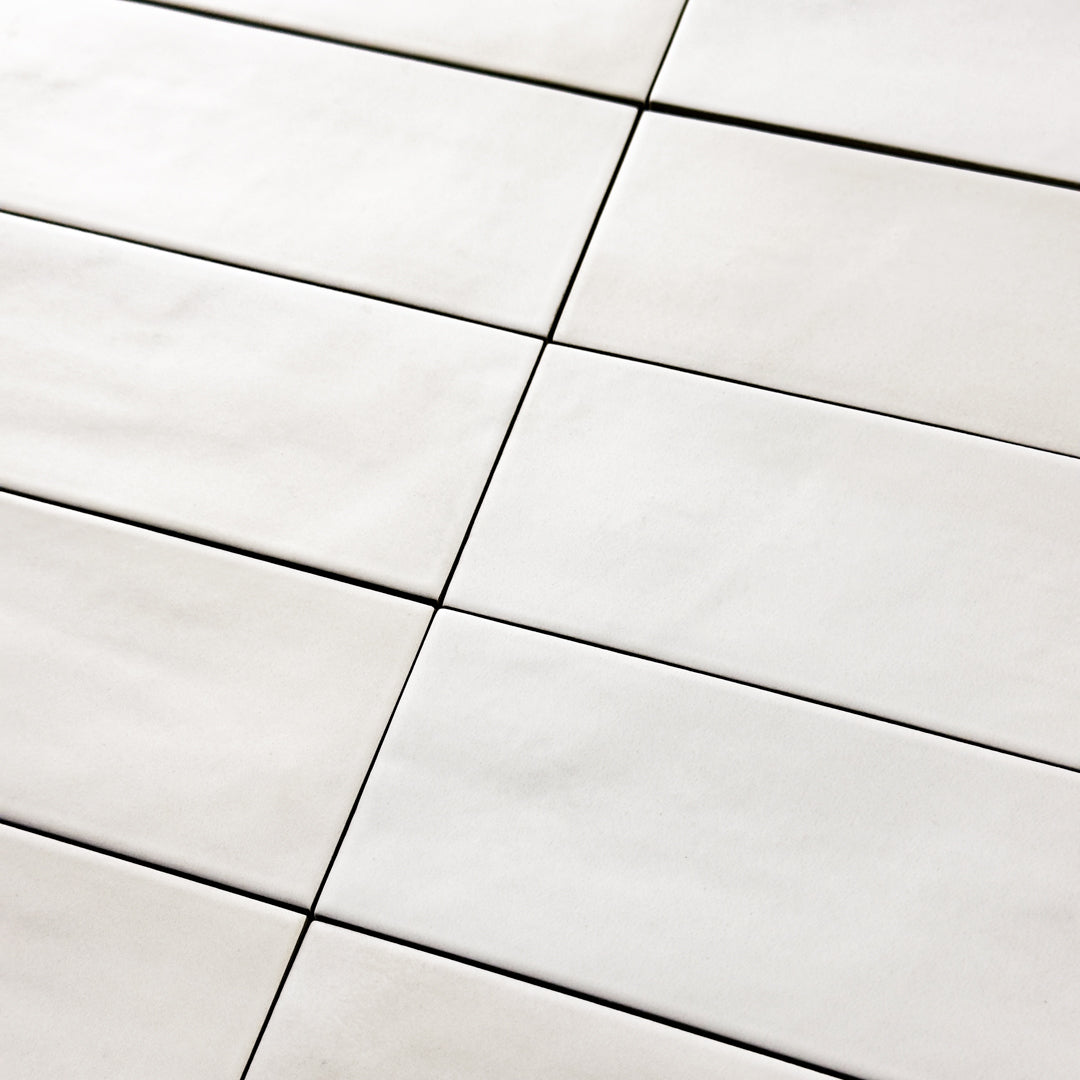 Close up detailed view of the 2x9 white matte subway tile laid out in a horizontal stack. 