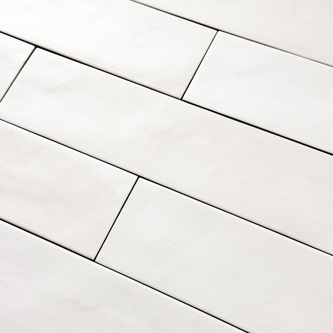 Close up detailed view of the white 2x9 matte subway tile laid out in a brick pattern. 