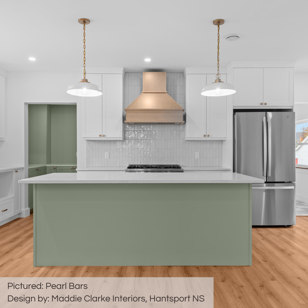 A stunning new kitchen designed with touches of light sage green, a stunning gold range hood and white cabinets. the pearl bars subway tiles shine and offer a timeless handmade charm! 