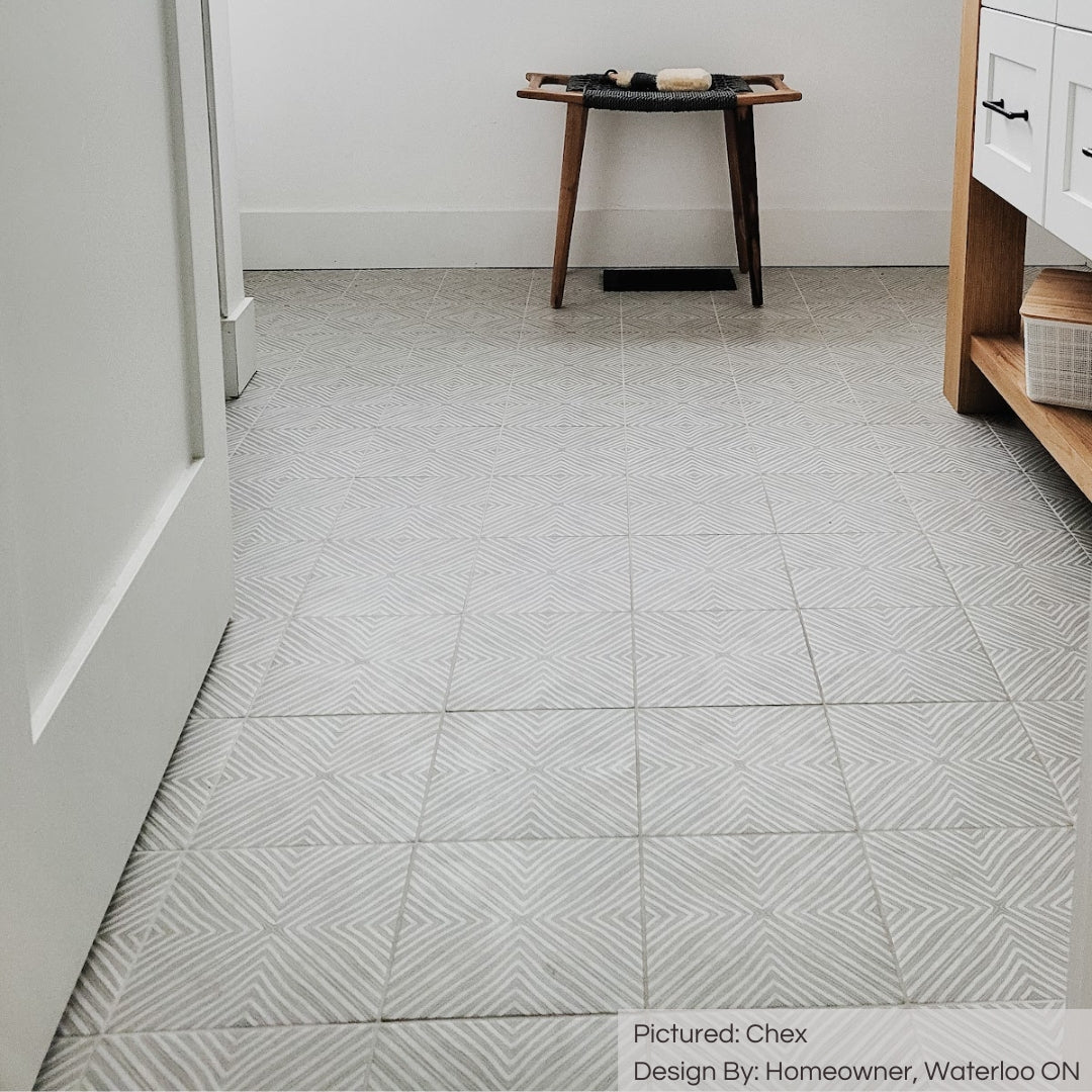 A close up of a bathroom floor using chex 8x8 pattern grey and white tiles. This angle shows the matte finish. 