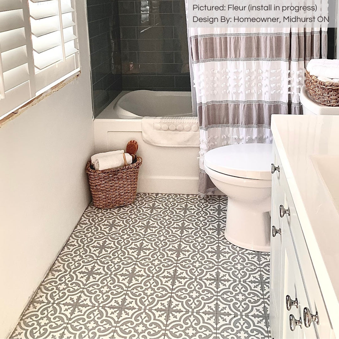 A beautiful bathroom with light finishes and a fun but classic pattern on the floor. the timeless fleur flower pattern grey and white tiles. 