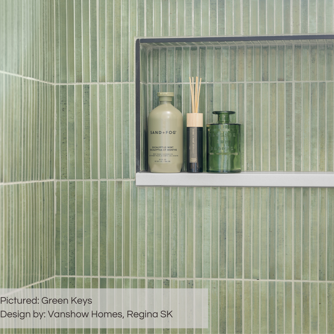 A close up of a shower niche where the tiles on the wall and inside the niche are green keys fluted panel tiles. the grout is light to match the stone niche shelf and highlights each reed of the tile design. 