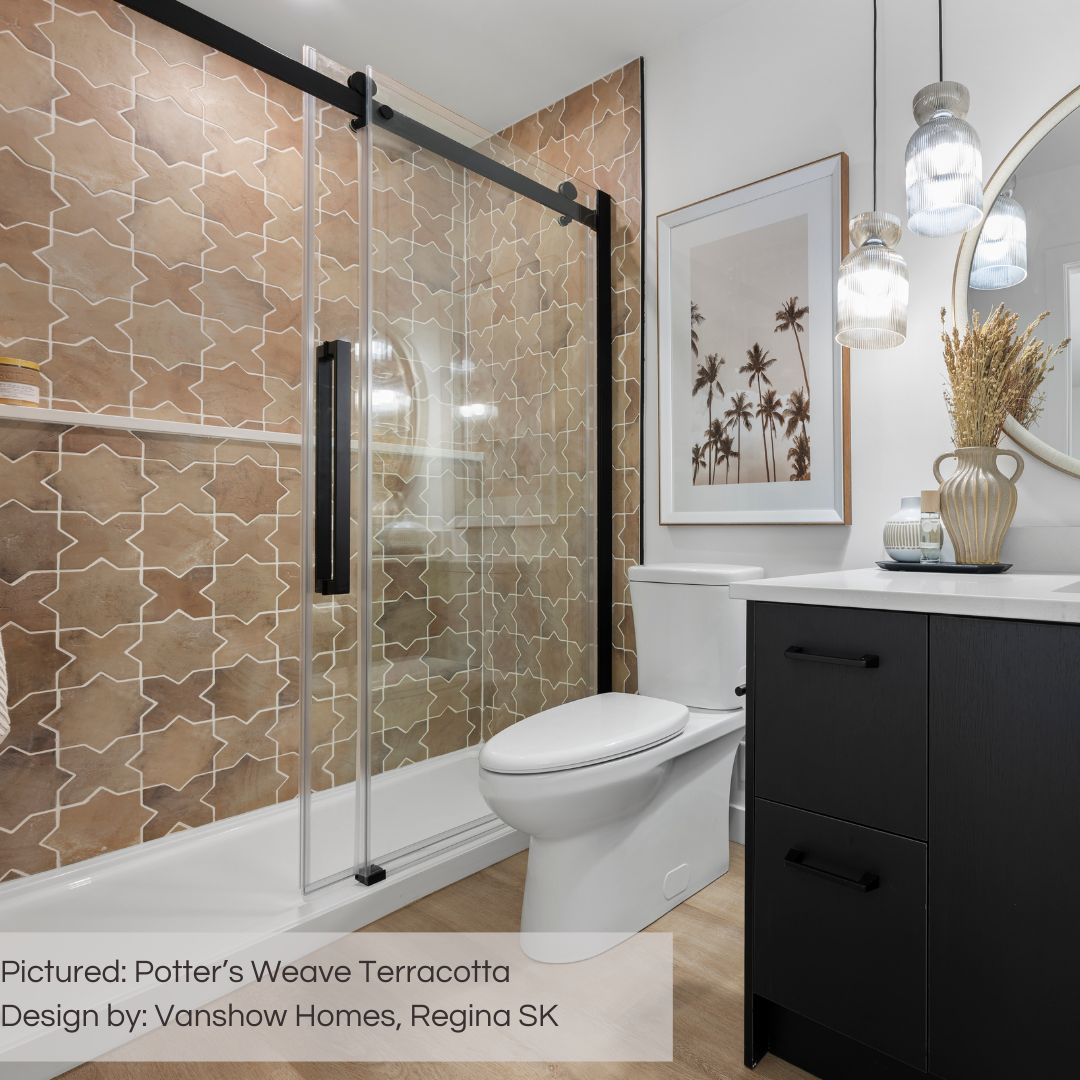 A modern bathroom with beige and black decor. The shower walls are a gorgeous star and cross tile in a variated stone look terracotta colourway. The browns in the tile match the wood flooring nicely.