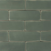 ariel view of a group of  dark moss fir green 2x6 matte subway tiles with a soft texture and uneven edges in a brick layout. 