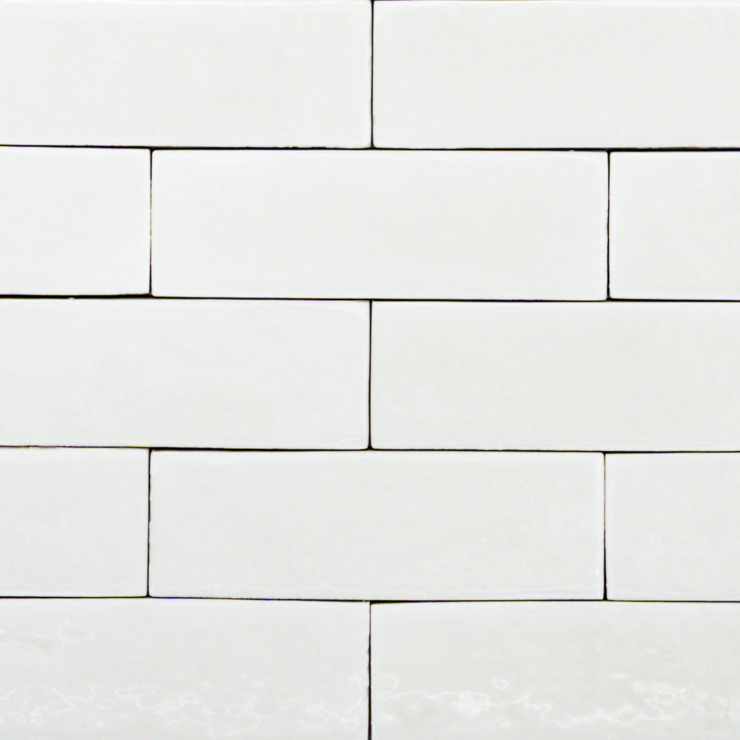a group of popcorn cloud white 2x6 glossy subway tiles with a soft texture and uneven edges in a brick layout. 