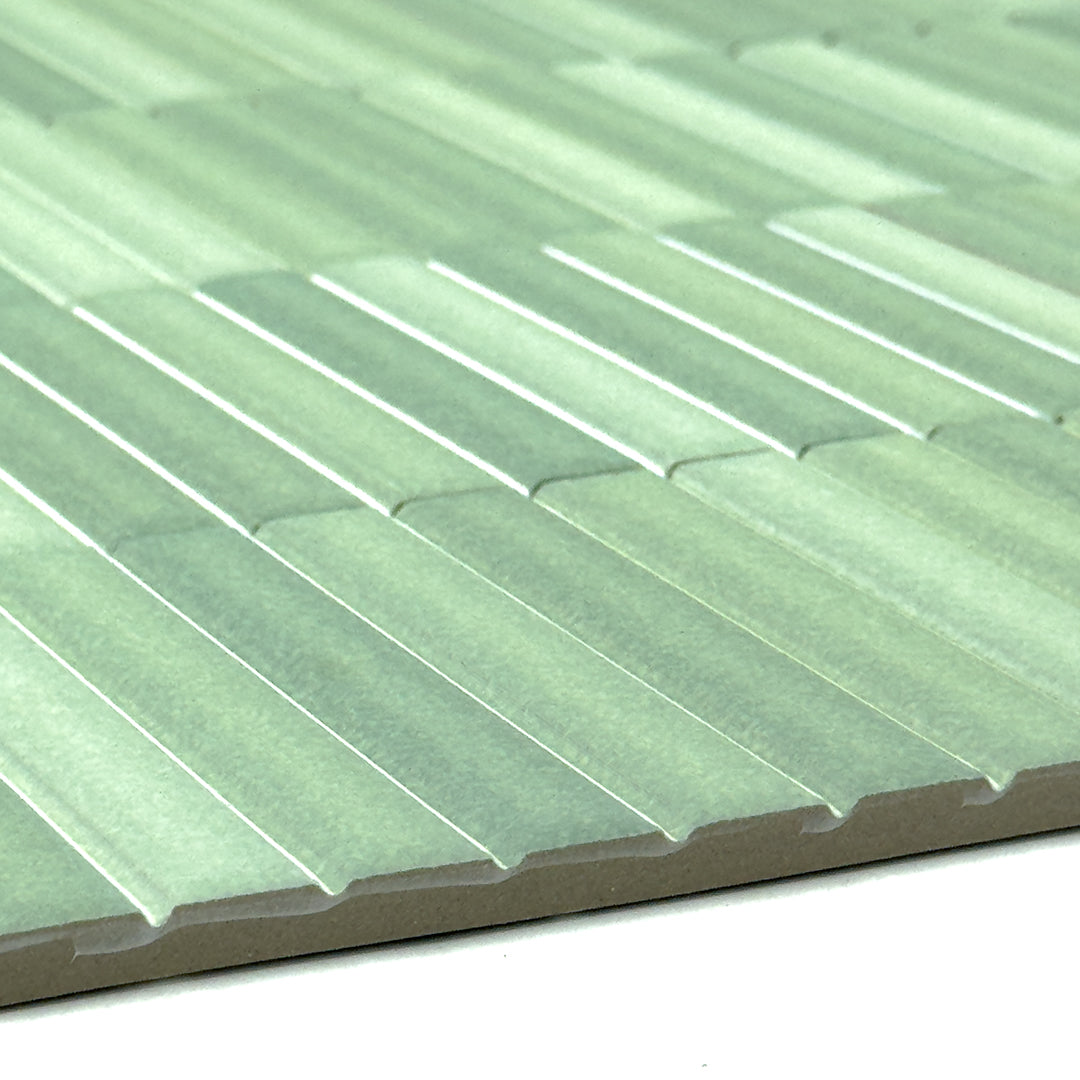 a close up of the surface of a group of fluted kitkat style panels in matte green with colour variation