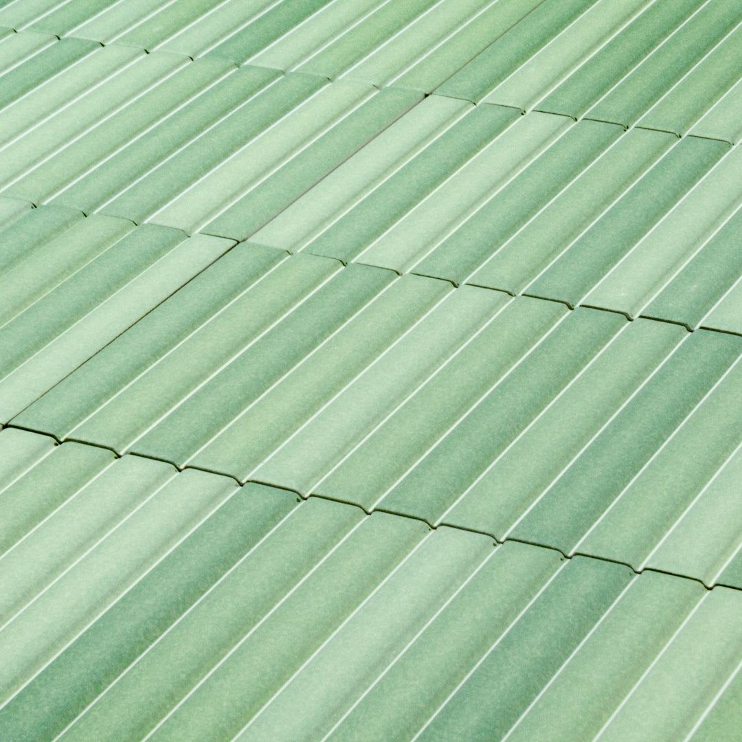 a group of fluted kitkat style panels stacked in matte green with colour variation