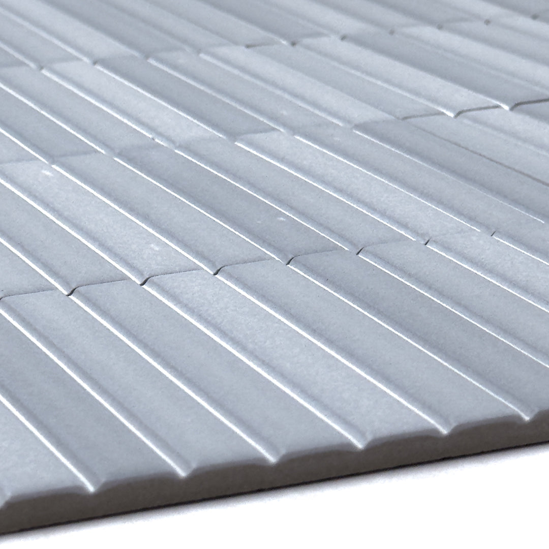 angled close up of a group of fluted kitkat style panel in matte ash blue grey with a soft colour variation