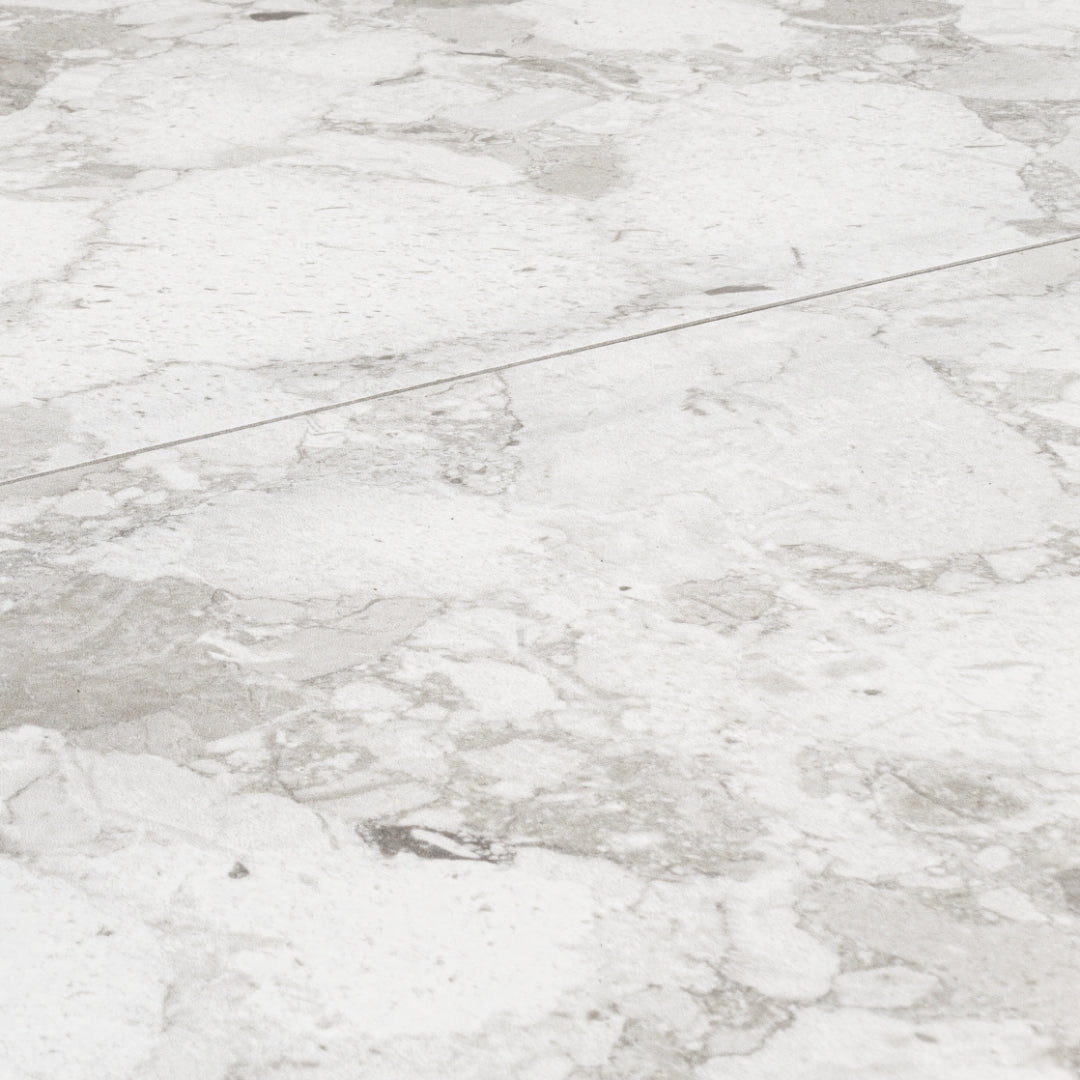 Angled close up of two 12x24 light grey Rainstone mist terrazzo look tiles. 