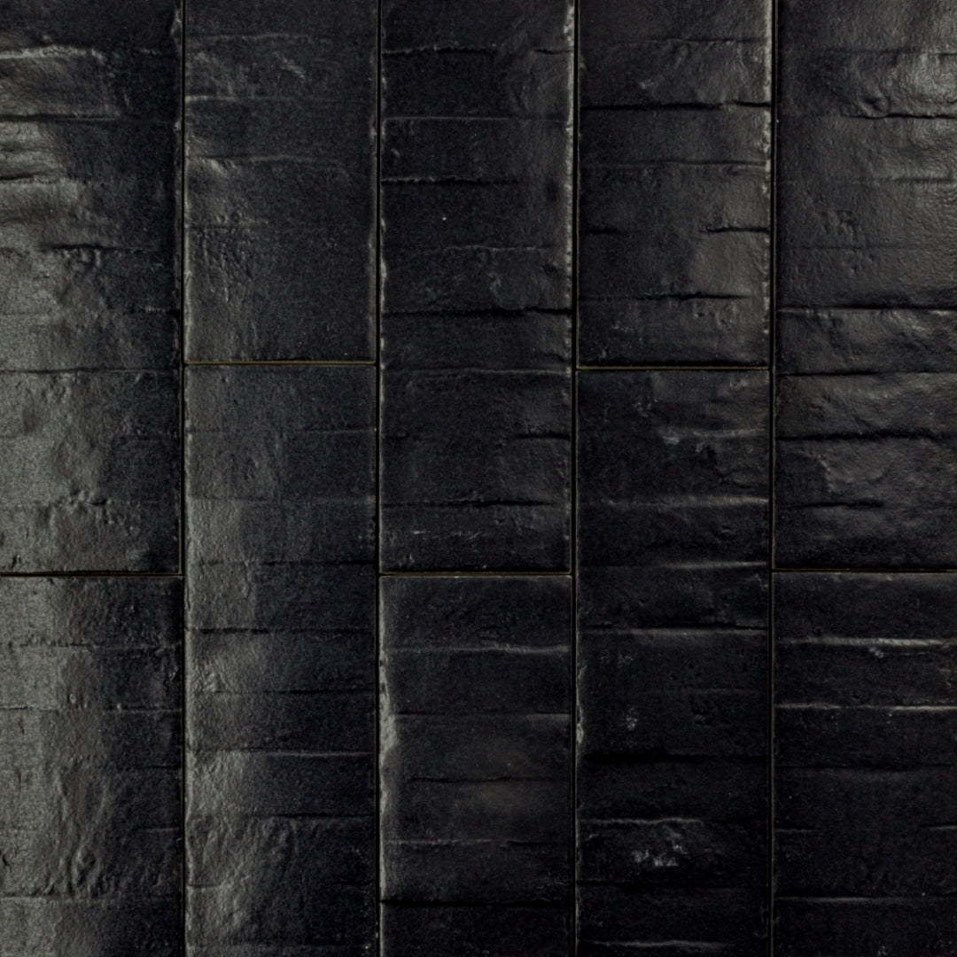 Ariel view of 3x12 band textured licorice black tiles in a brick layout. 