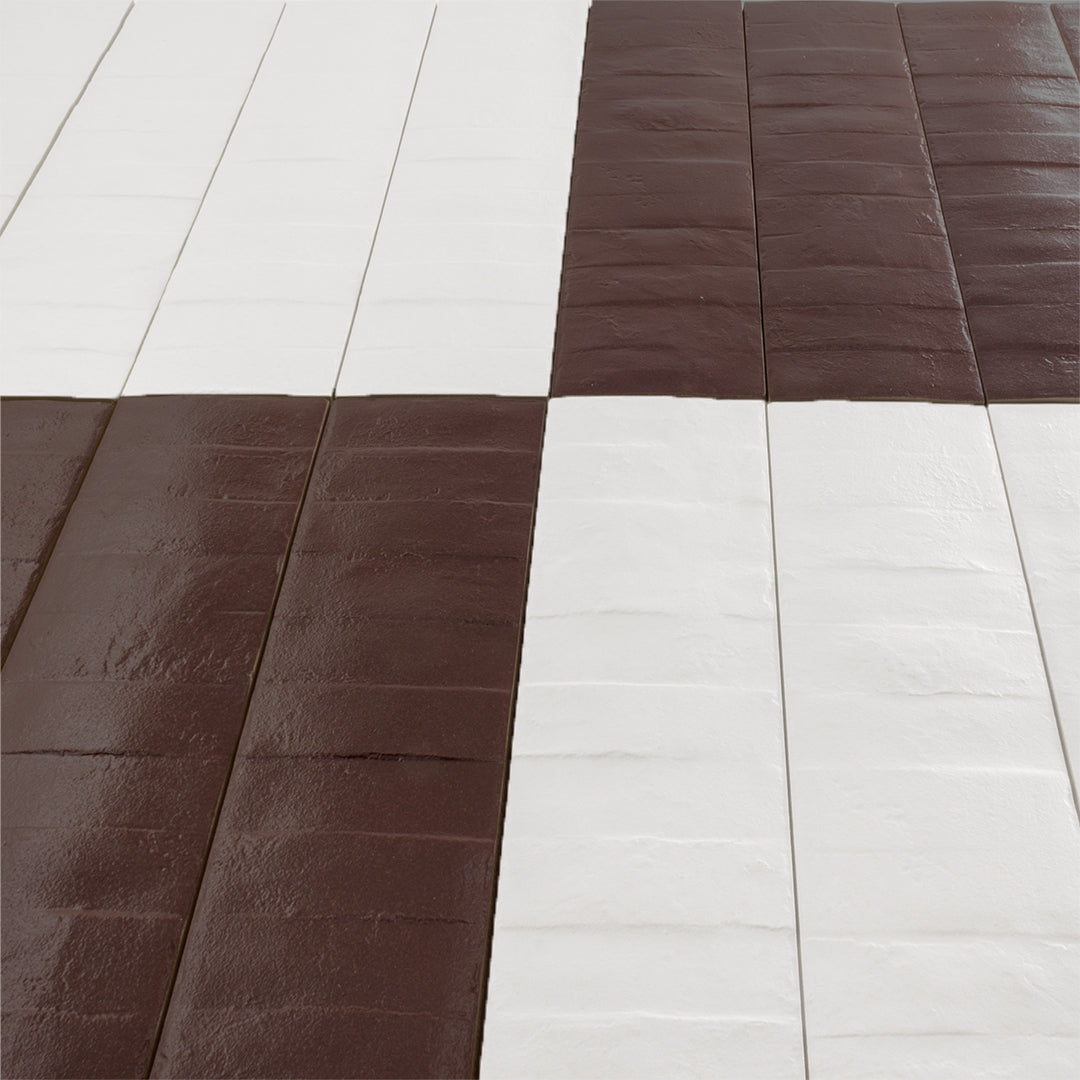 Angled close up view of a checkerboard pattern layout of 3x12 white and burgundy textured tiles. 