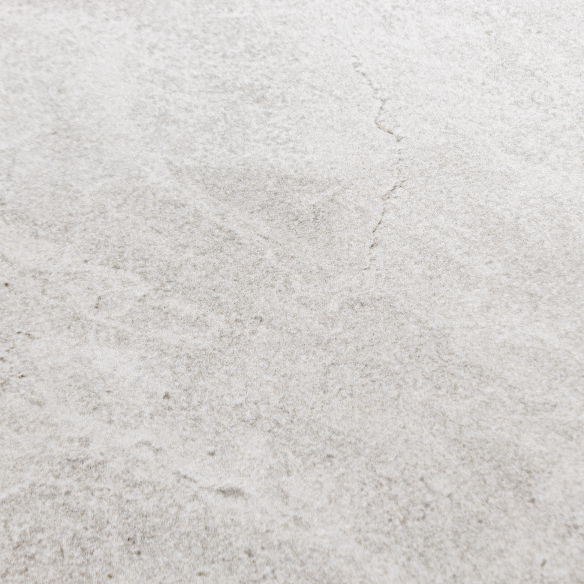 Close up of a single large rectangular white stone look tile showing the colour and pattern. 