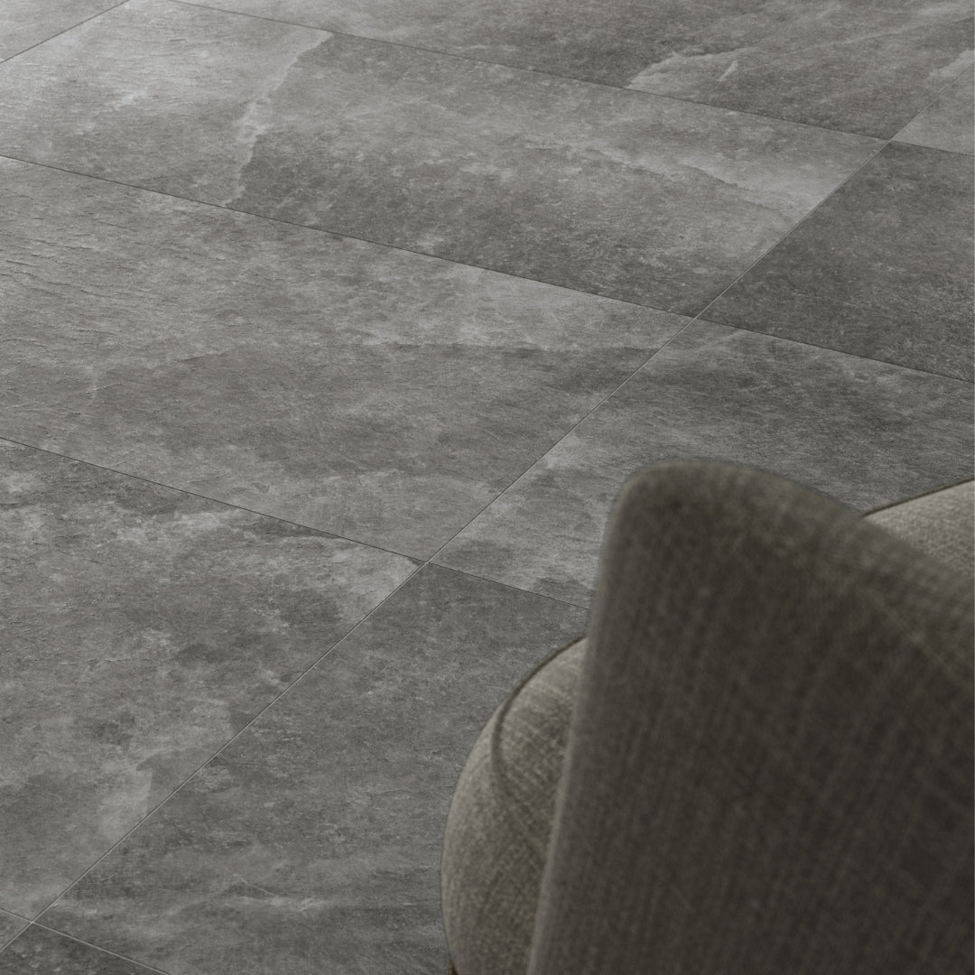 Angled close up view of a seating area. The tiled floors are a dark stone look grey tile with veining and earthy vibe. 