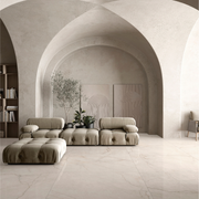 A neutral modern living space with limewash walls, arches and monochromatic look and warm white cream marble look tile flooring with fine delicate gold beige veining known as sanctuary avorio