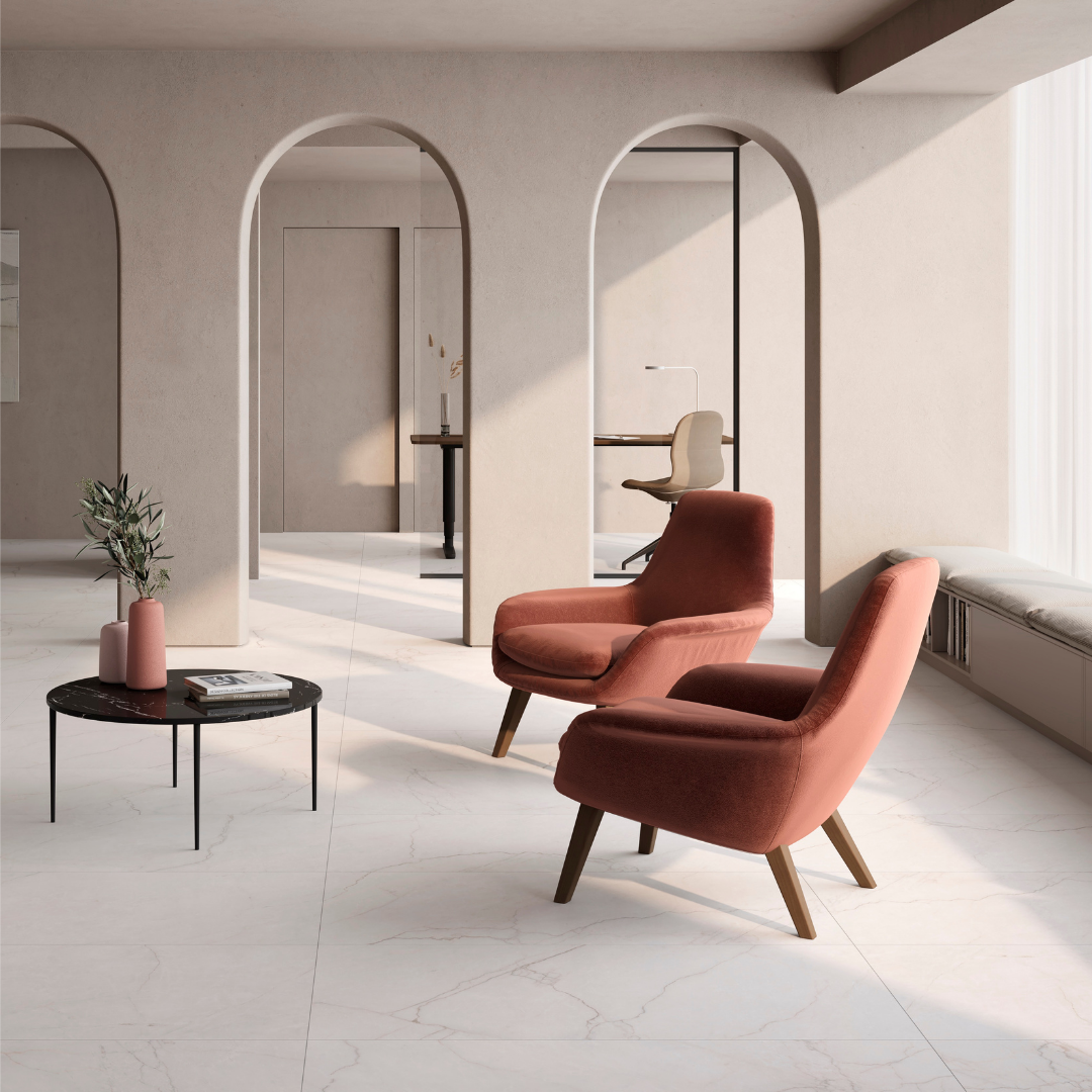 A modern seating area with cozy furniture with beige walls and bright white marble flooring with fine delicate grey veining known as sanctuary bianco 