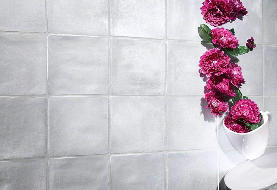 Close up of a the subtle sky blue 4x4 zellige tiles with textured edges installed with light grout and bright area. 