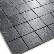 Angled close up view of a 2 inch square 12x12 sheet mosaic in a slate look black stone to highlight the texture and pattern. 