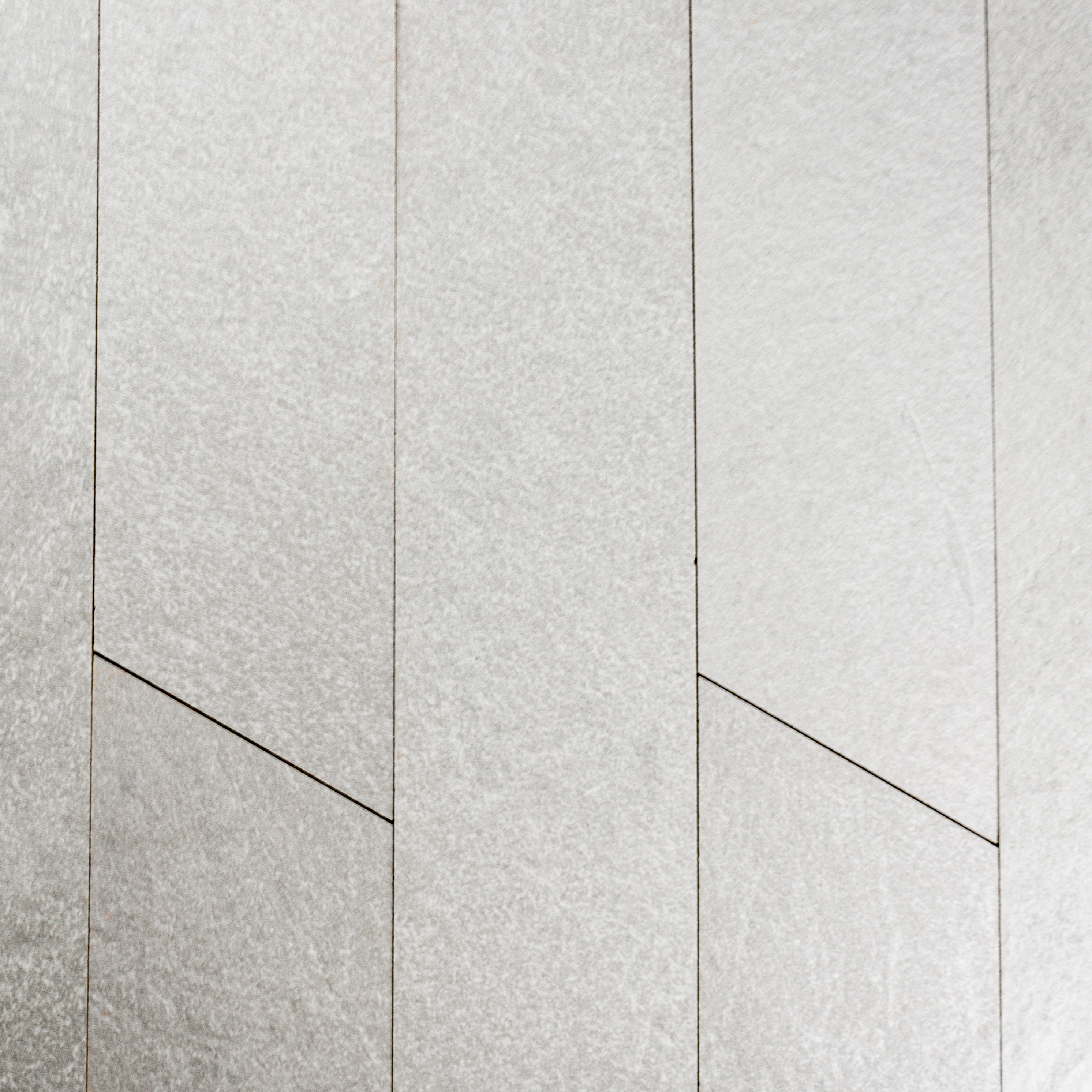 Ariel view of a group of 4x20 white chevron stone look tiles to highlight the colour, pattern and shape.