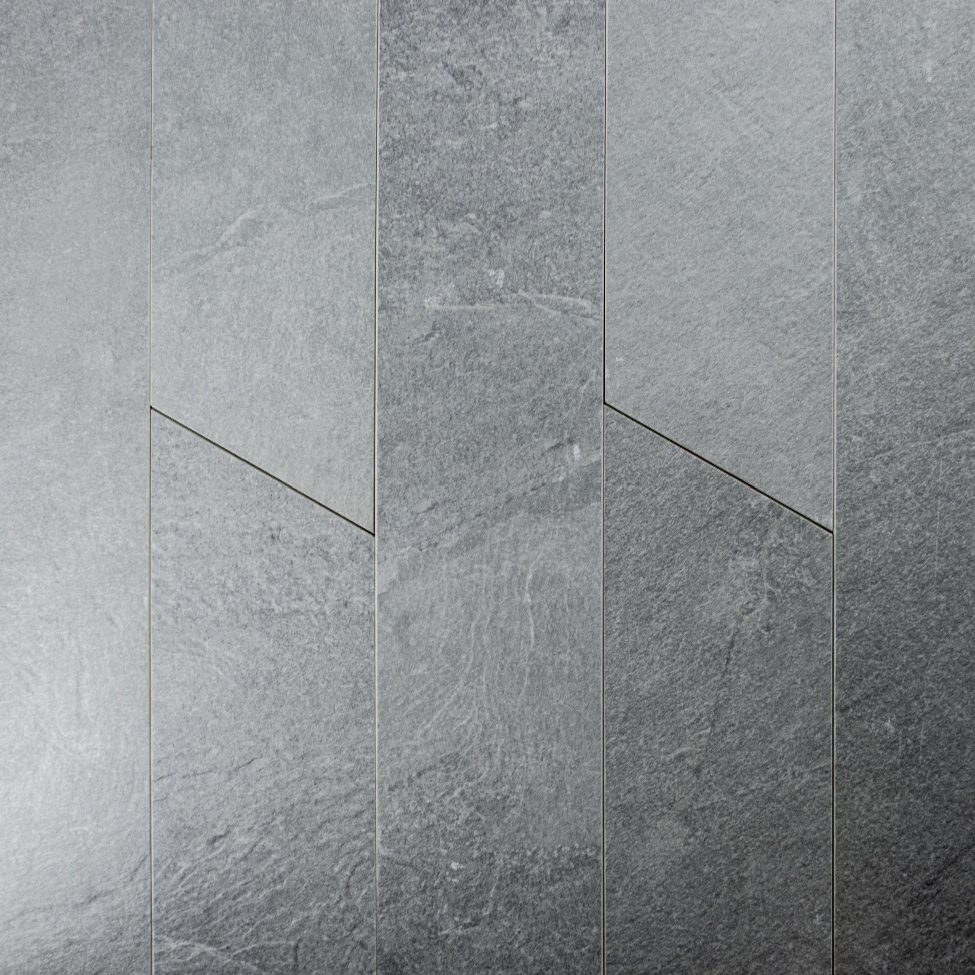 Ariel shot of a group of 4x20 grey chevron stone look tiles to highlight the pattern, colour variation and shape. 