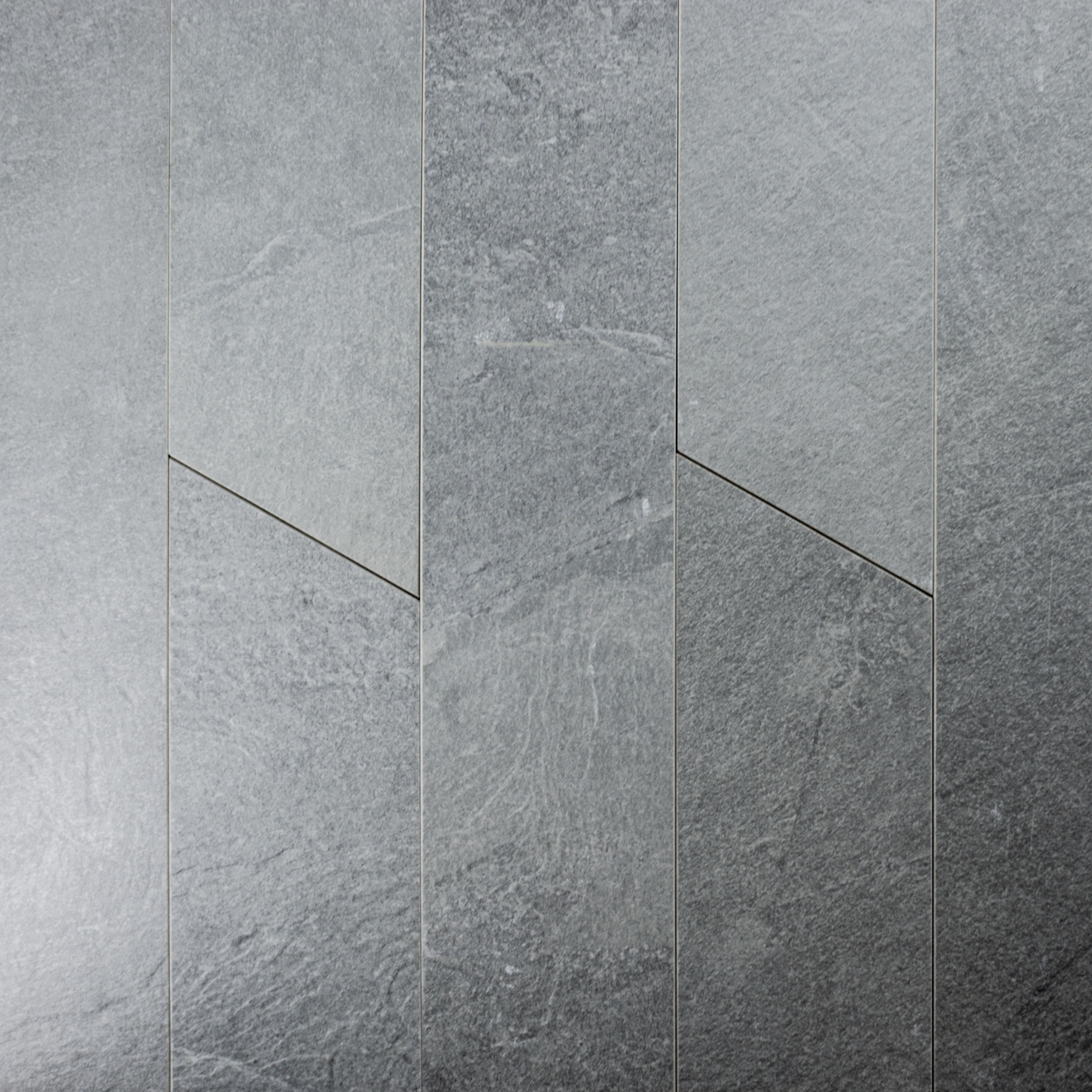 Ariel shot of a group of 4x20 grey chevron stone look tiles to highlight the pattern, colour variation and shape. 