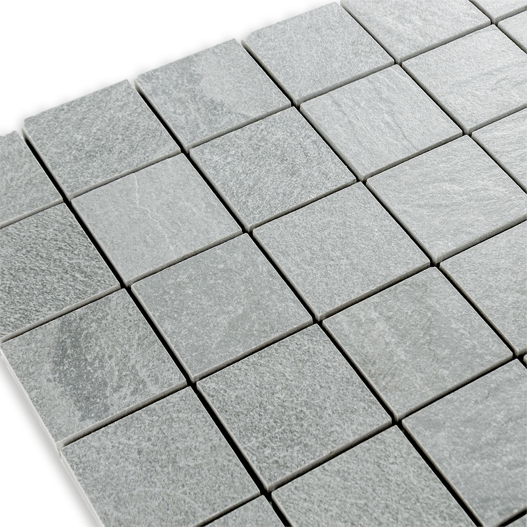 Angled close up view of a 2 inch square 12x12 sheet mosaic in a slate look grey stone. 