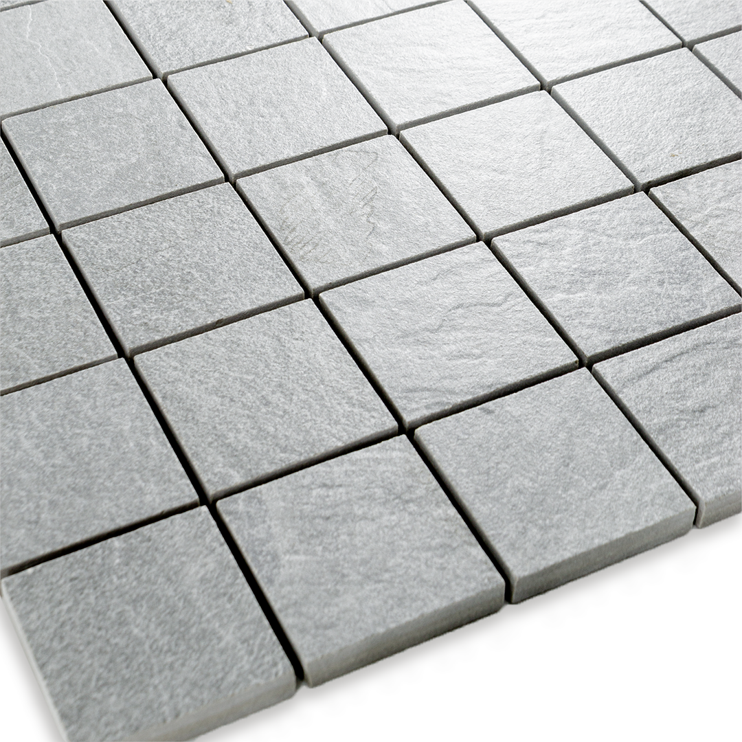Angled close up view of a 2 inch square 12x12 sheet mosaic in a slate look grey stone. 