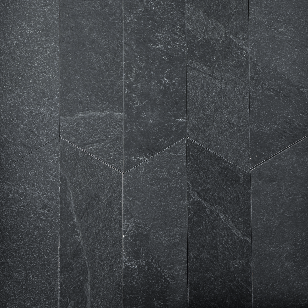 Ariel view of a group of black slate look 4x20 chevron tiles to show the shape,  matte finish, colour and veining pattern. 