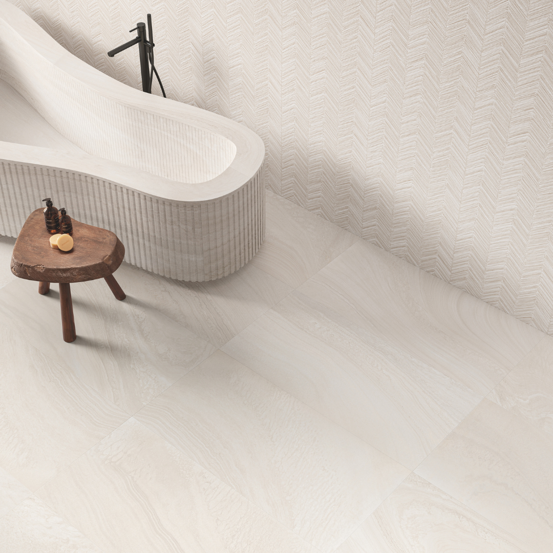 Ariel view of a ensuite bathroom with a standalone bathtub. the floors are tilesinspired solenne white in a rectangle format with the soft stone pattern offering a minimalist modern look. the walls are tilesinspired solenne white structured which has a chervron look pattern of the same stone colour and finish. 