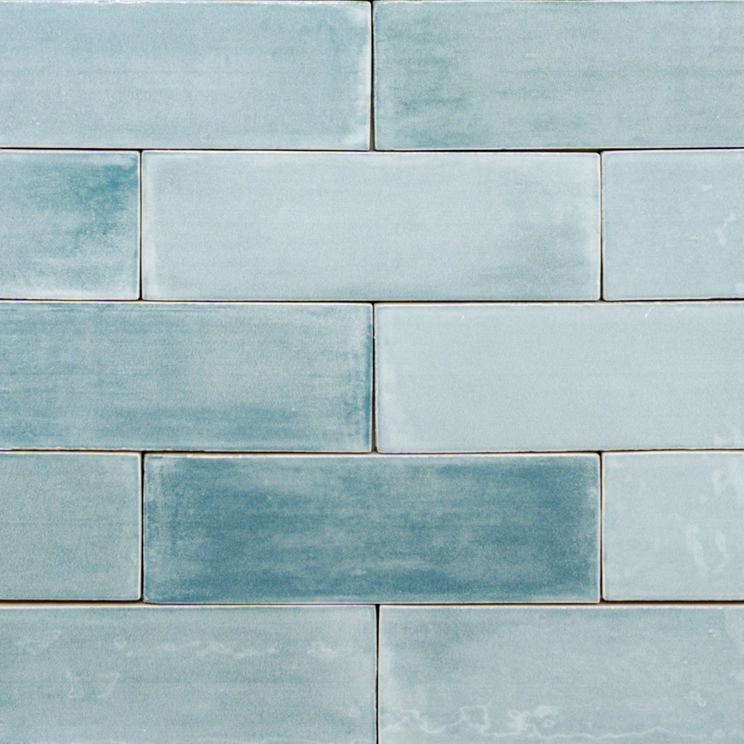 a group of 2x6.5 glossy aqua blue subway tiles with colour variation in a brick layout